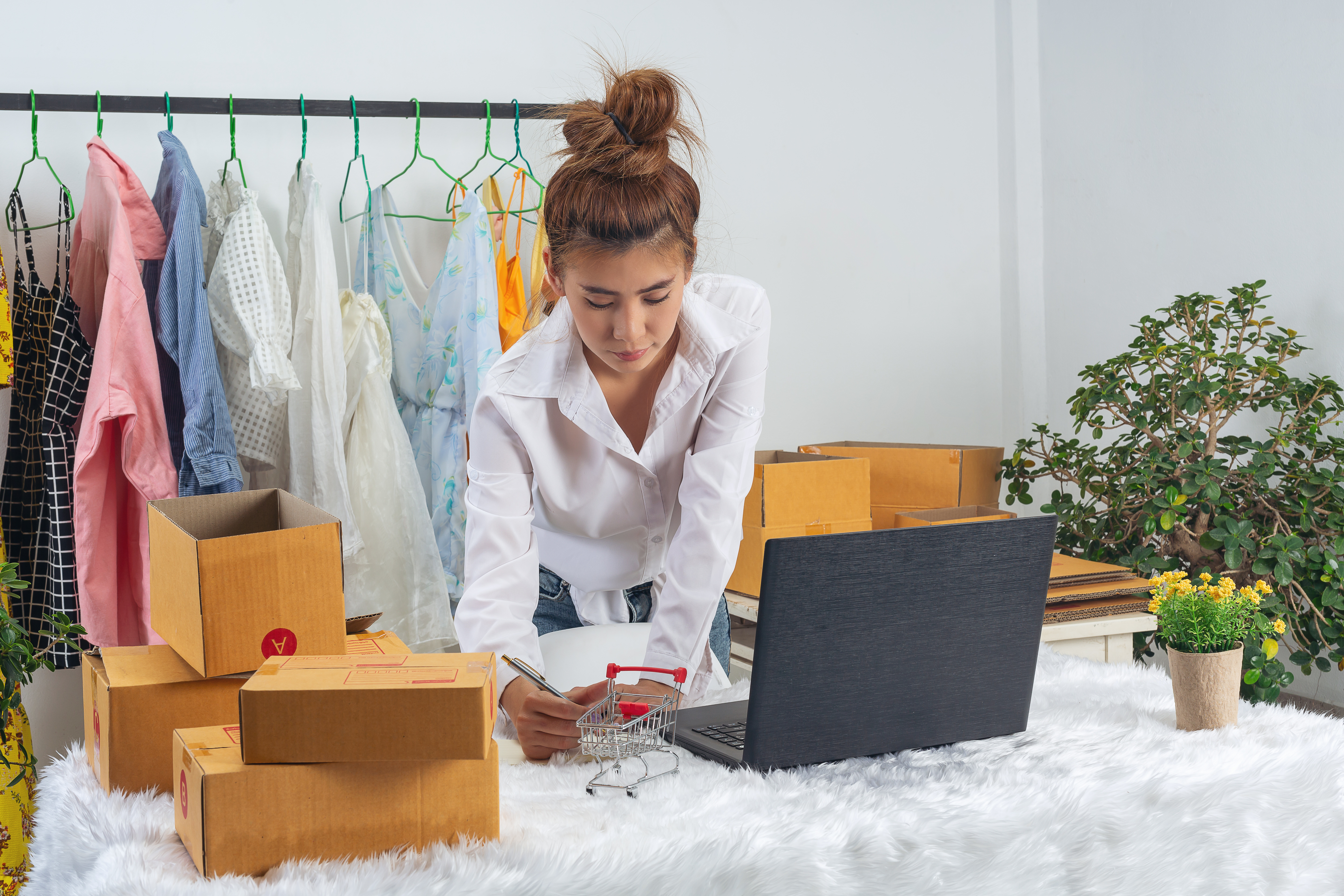 A business woman is working online and traing to reply customer  at home office packaging on background.